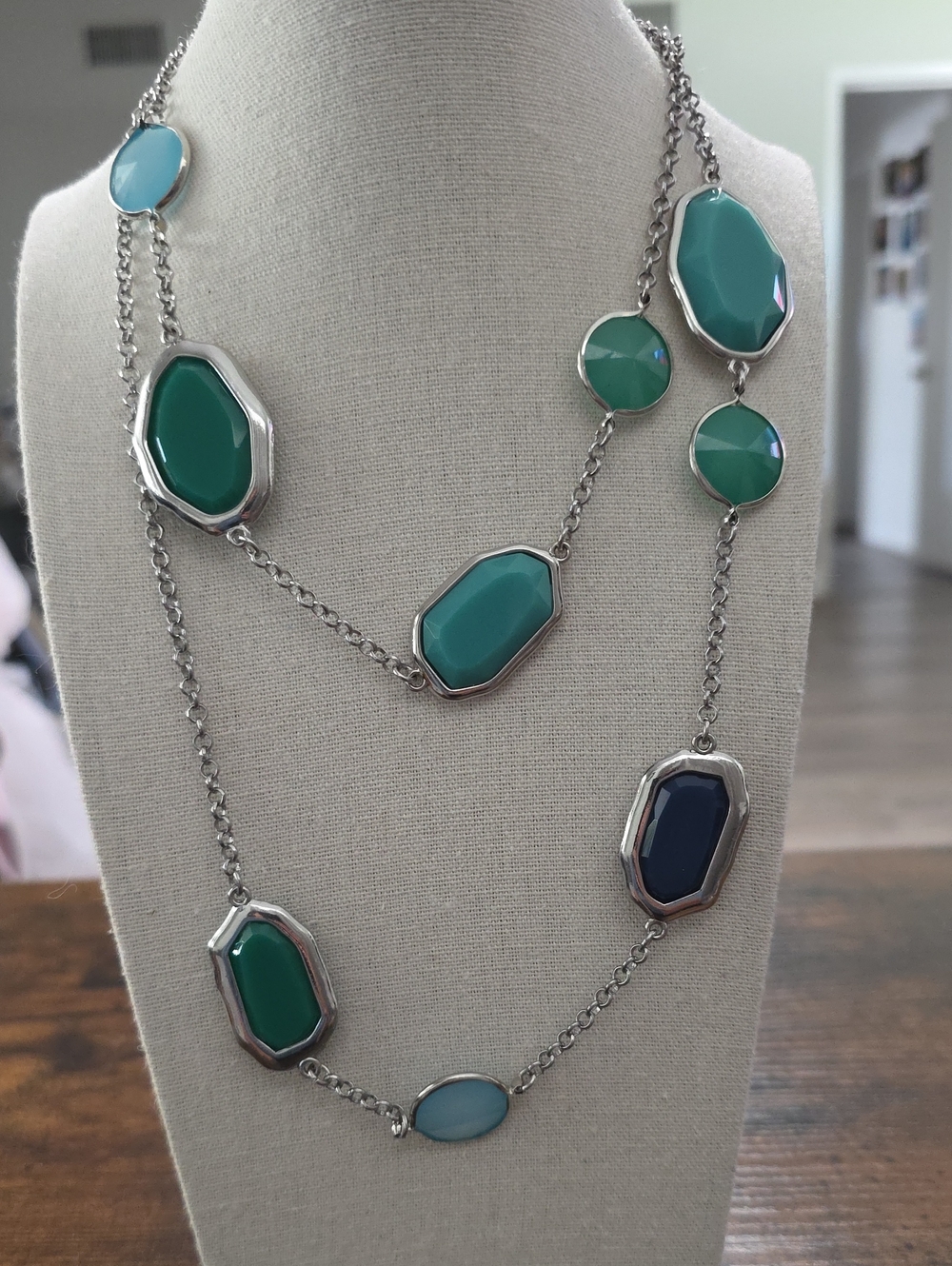 This Premier Designs necklace features faceted teal, blue, and navy stones set